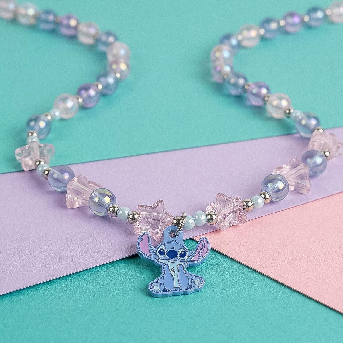 Collana bigiotteria a tema Stitch con elementi a forma di stella, tondi e a cuore e un pendente a forma di Stitch. Fuori dalla confezione di cartone