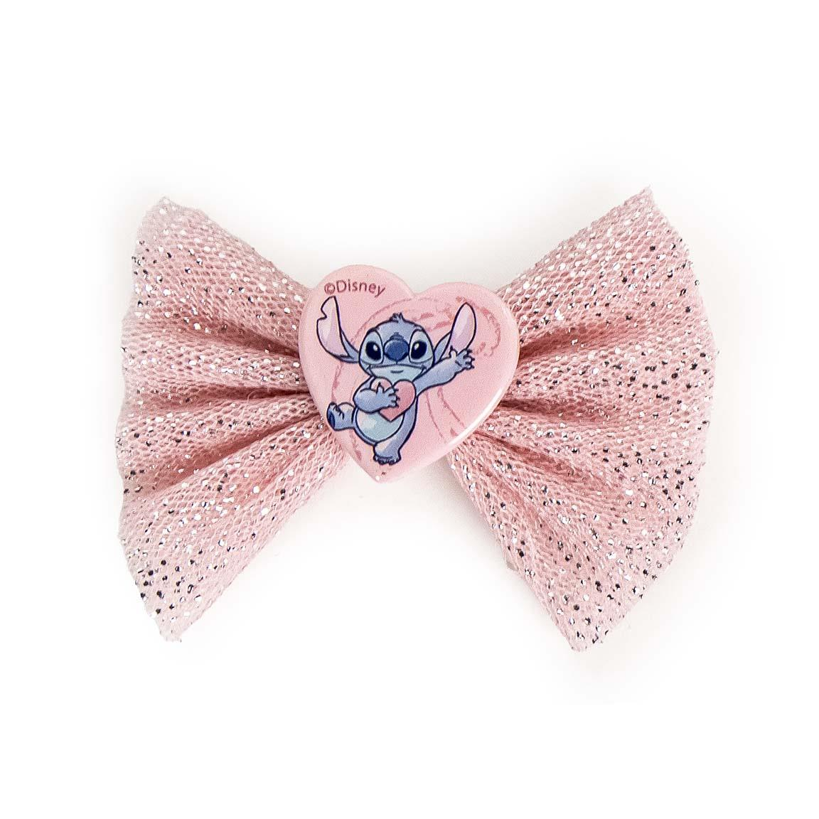 Set accessori per capelli a tema Stitch. Il set è composto da un comodo zainetto in plastica con la stampa di Stitch. All'interno si trovano un fiocco, 6 fermagli per capelli e 9 piccoli elastici per capelli, tutti a tema Stitch. Nella foto, il fiocco di Stitch, rosa e brillantinato, con al centro un cuore rosa e la stampa di stitch 