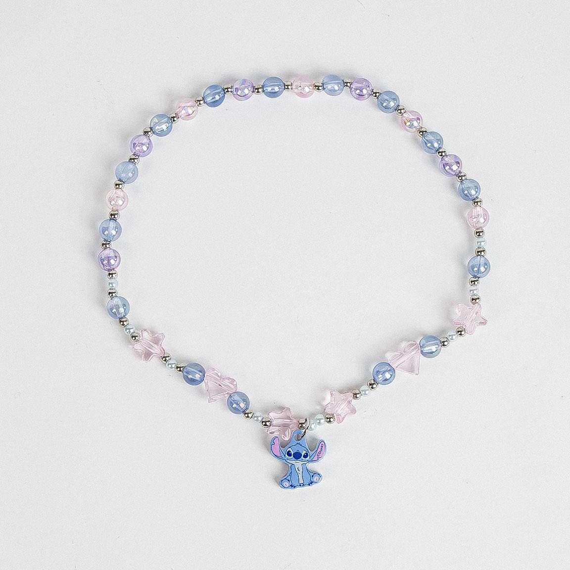 Collana bigiotteria a tema Stitch con elementi a forma di stella, tondi e a cuore e un pendente a forma di Stitch. Foto della collana fuori dalla confezione di cartone e posta su un piano 