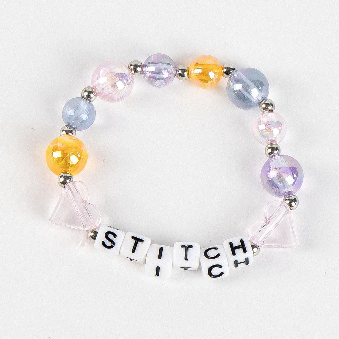 Set di bigiotteria a tema Stitch composto da tre bracciali. Uno presenta la scritta Stitch, uno un pendente a forma di Angel ed uno ha una forma a molla ed ha i colori dell'acrobaleno pastello. Foto del bracciale con la scritta "Stitch"