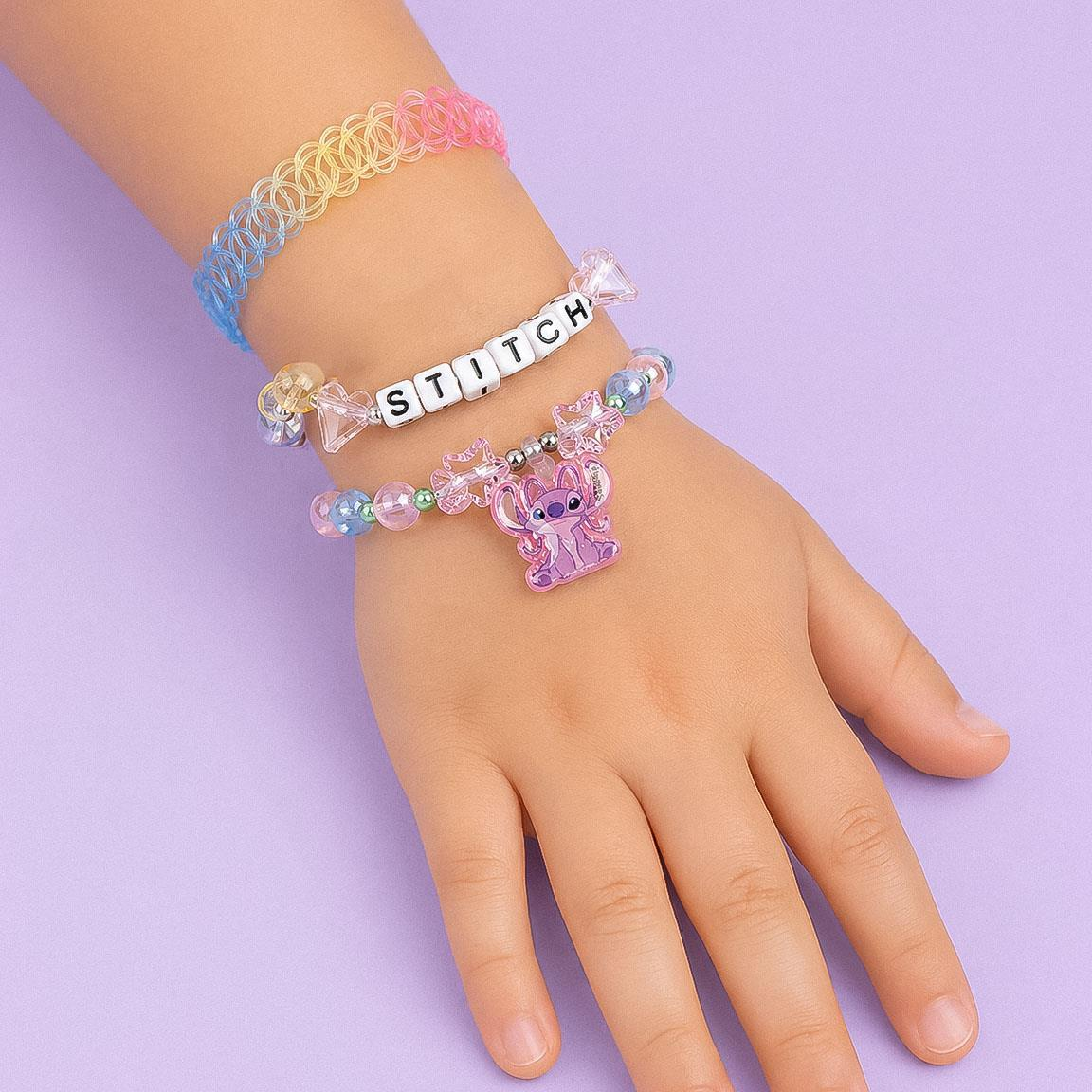Set di bigiotteria a tema Stitch composto da tre bracciali. Uno presenta la scritta Stitch, uno un pendente a forma di Angel ed uno ha una forma a molla ed ha i colori dell'acrobaleno pastello. Foto dei bracciali indossati sul braccio di una bambina 